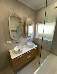 After photo of the Blackburn VIC bathroom renovation showing double vessel basins, timber vanity and oval mirrors